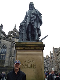 Patrick Grady standing in front of statue of Adam Smith in Edinburgh, Scotland